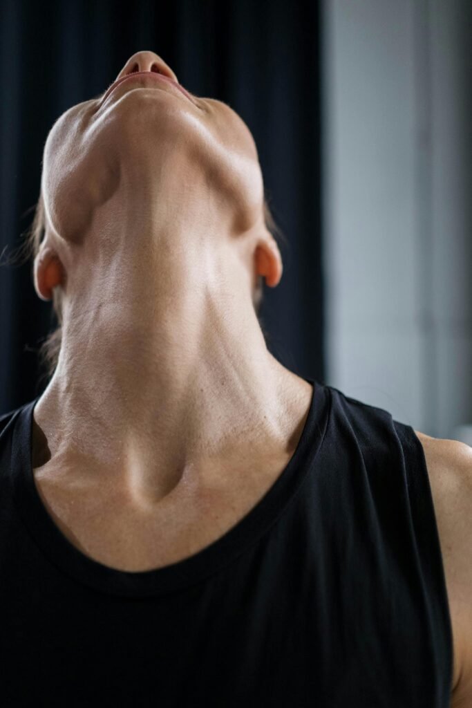 Detailed shot of a woman stretching her neck in a fitness setting.